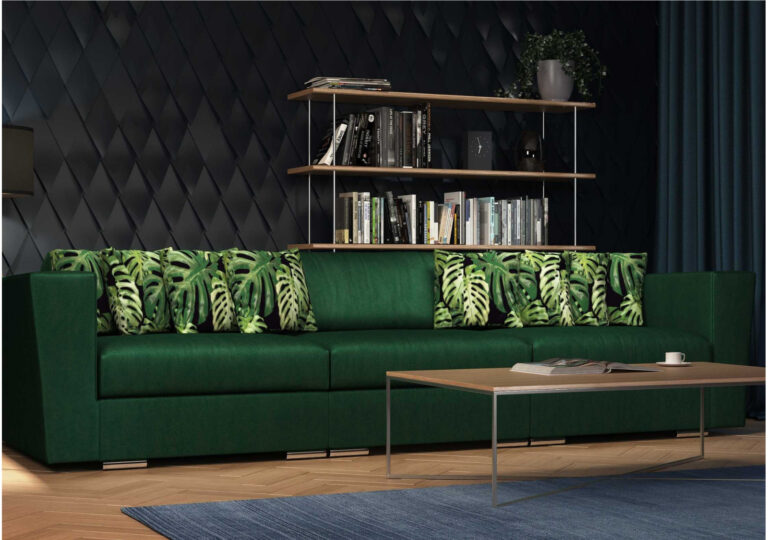 Butelkowozielona sofa modułowa z poduszkami w liście monstery przy ciemnej pikowanej ścianie